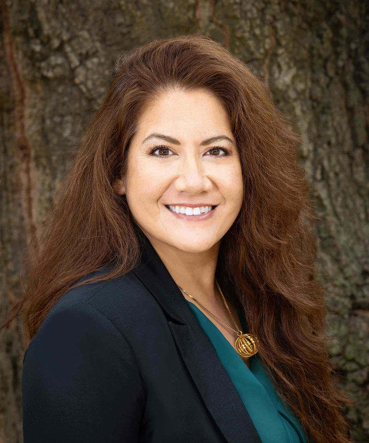 Portrait of Carolyn Garrison standing beside an oak tree.